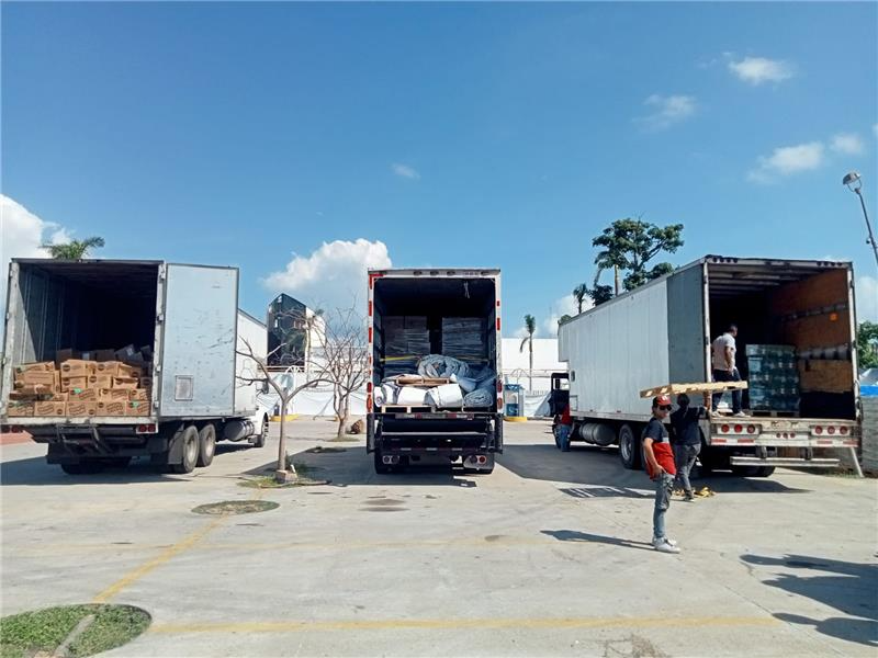 Trabajadores cargando remolques con carga de socorro para acapulco